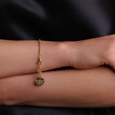 A model wearing a delicate gold chain bracelet with a small circular gold charm and lobster clasp all in 24K yellow gold finish over 925% sterling silver. The gold bracelet is designed from the iconic DelBrenna Links collection - Italian jewelry designs hand-crafted in Tuscany.